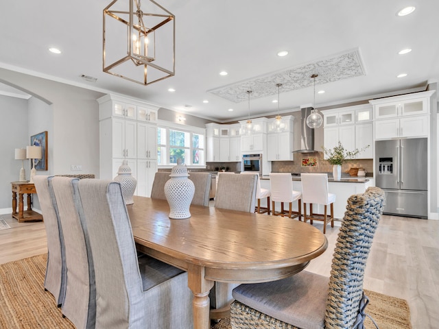 61 Sweet Breeze Dr, Santa Rosa Beach, FL 32459 - dining space featuring light wood-style floors, arched walkways, recessed lighting, a chandelier, and ornamental molding