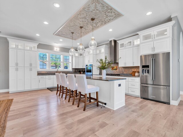61 Sweet Breeze Dr, Santa Rosa Beach, FL 32459 - kitchen featuring stainless steel appliances, wall chimney exhaust hood, a center island, decorative backsplash, and white cabinets