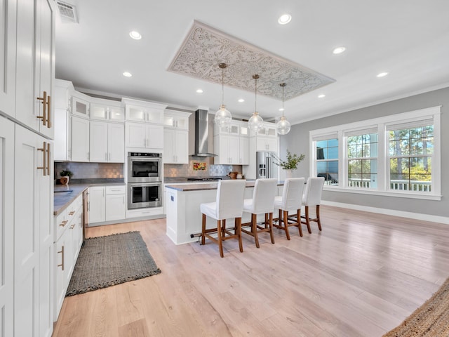 61 Sweet Breeze Dr, Santa Rosa Beach, FL 32459 - kitchen featuring wall chimney exhaust hood, stainless steel appliances, a center island, backsplash, and crown molding