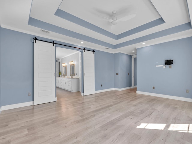 61 Sweet Breeze Dr, Santa Rosa Beach, FL 32459 - unfurnished bedroom featuring a raised ceiling, a barn door, baseboards, and recessed lighting