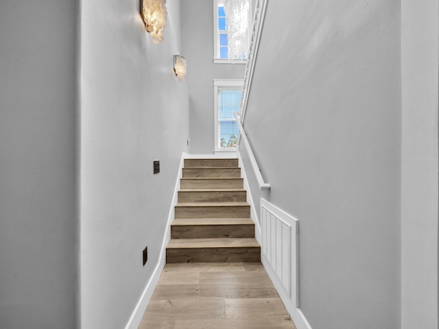 61 Sweet Breeze Dr, Santa Rosa Beach, FL 32459 - stairway featuring wood finished floors, baseboards, and a high ceiling