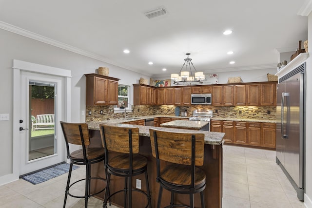 kitchen featuring pendant lighting, light tile patterned floors, a kitchen breakfast bar, and appliances with stainless steel finishes