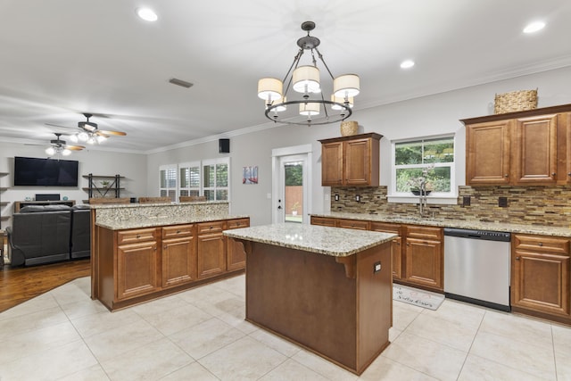 kitchen with a kitchen island, decorative light fixtures, tasteful backsplash, dishwasher, and crown molding