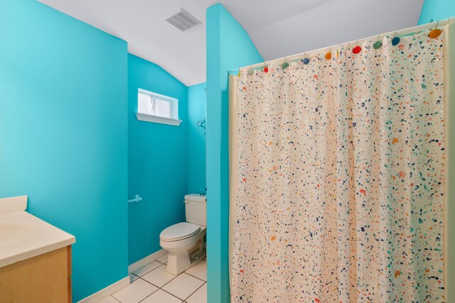 bathroom featuring vanity, tile patterned flooring, lofted ceiling, and toilet