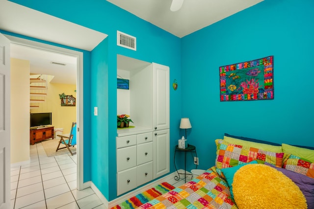 tiled bedroom featuring ceiling fan