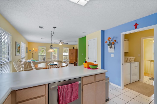 kitchen featuring pendant lighting, washing machine and clothes dryer, light brown cabinetry, and light tile patterned floors