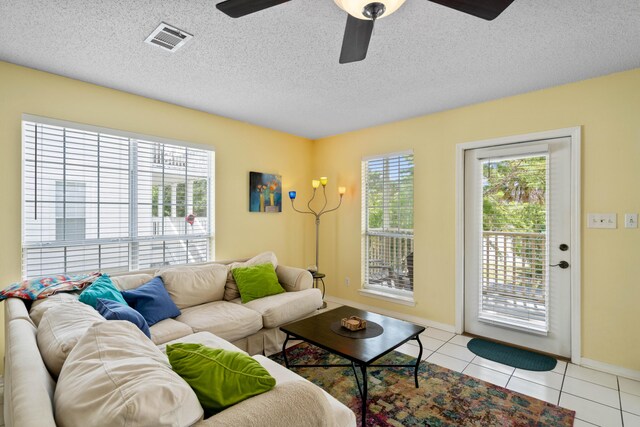 tiled living room featuring a textured ceiling and ceiling fan