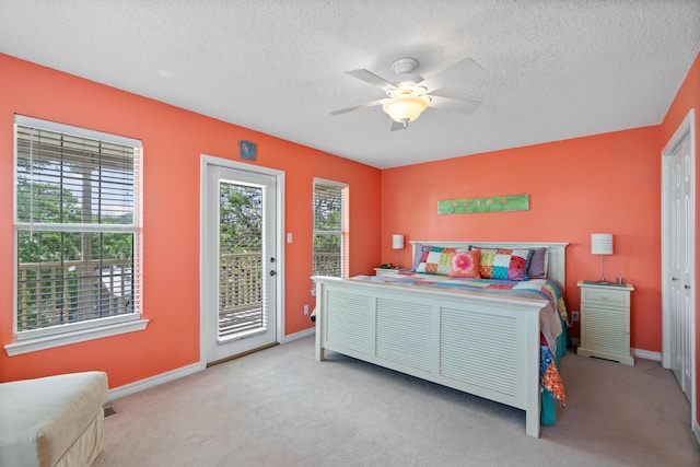 bedroom featuring access to exterior, light carpet, ceiling fan, and a textured ceiling