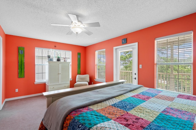 bedroom with carpet, access to outside, a textured ceiling, and ceiling fan