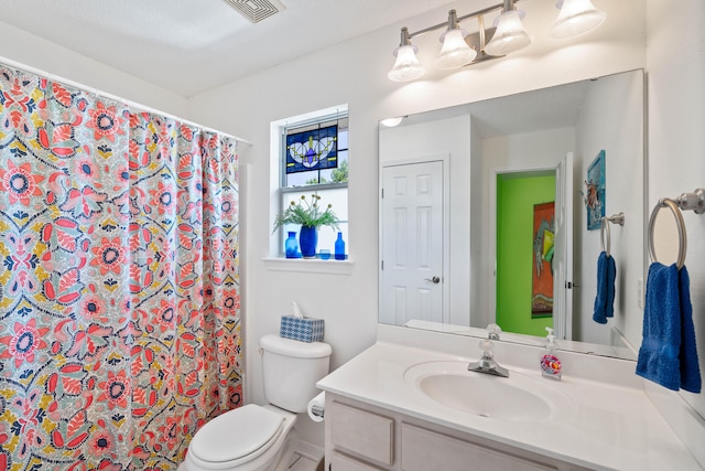 bathroom with vanity, curtained shower, and toilet