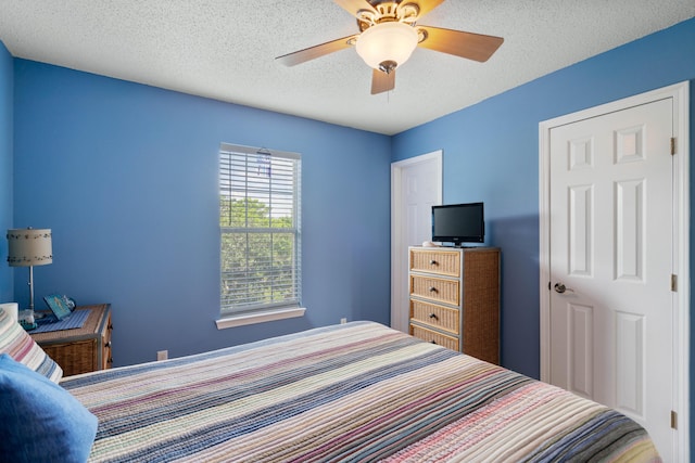 bedroom featuring ceiling fan and a textured ceiling