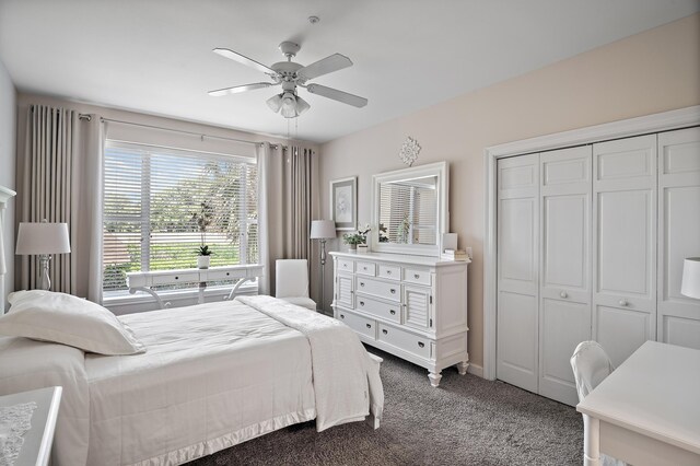 bedroom with dark colored carpet, ceiling fan, and a closet