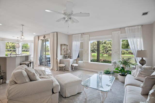 living room featuring sink, ceiling fan, and light tile patterned floors