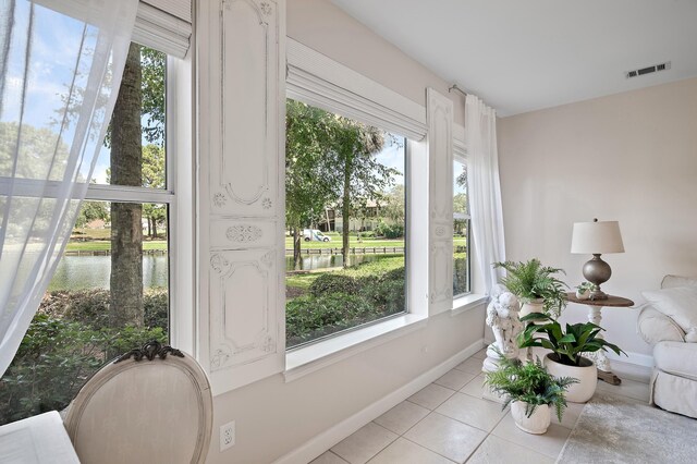 sunroom featuring a water view and a wealth of natural light