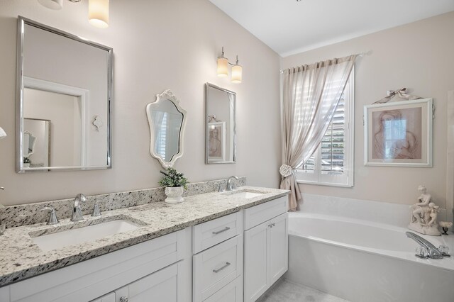 bathroom featuring a tub and double sink vanity