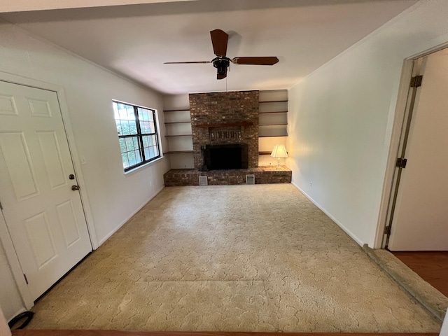 unfurnished living room with a brick fireplace, carpet, and ceiling fan