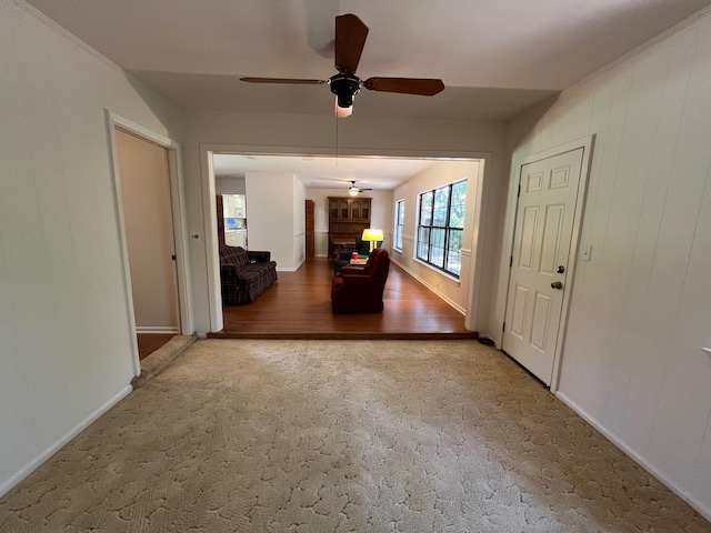 interior space with a brick fireplace and ceiling fan