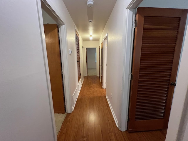 corridor with light hardwood / wood-style floors