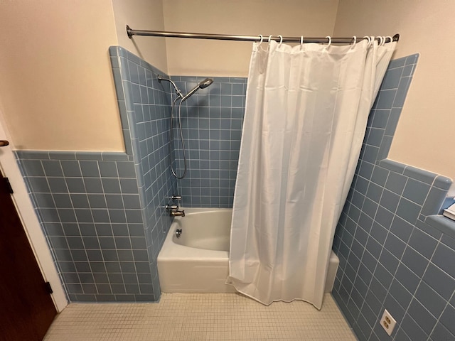 bathroom with tile patterned flooring, tile walls, and shower / bath combination with curtain