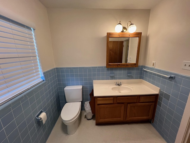 bathroom with vanity, tile walls, tile patterned floors, and toilet