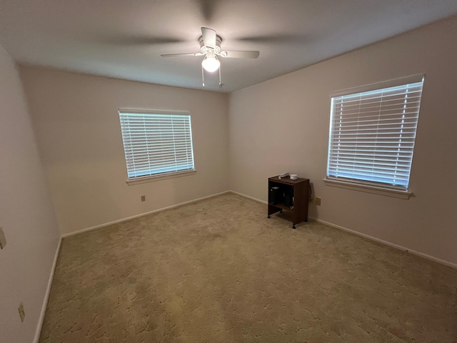 carpeted spare room with ceiling fan