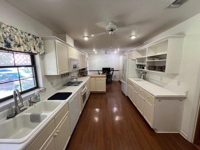 kitchen featuring sink, white appliances, dark wood-type flooring, and white cabinets