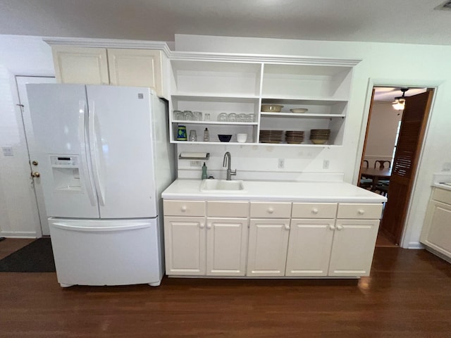 kitchen with sink, dark wood-type flooring, white fridge with ice dispenser, and white cabinets