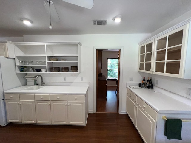 kitchen featuring dark wood-type flooring, sink, and white cabinets