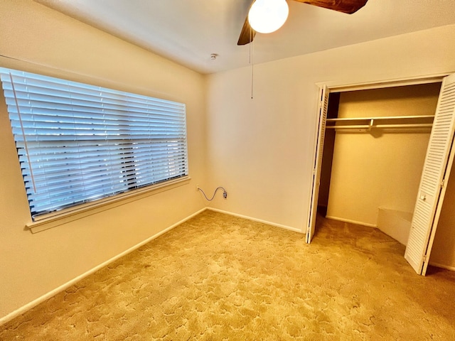 unfurnished bedroom with light carpet, a closet, and ceiling fan