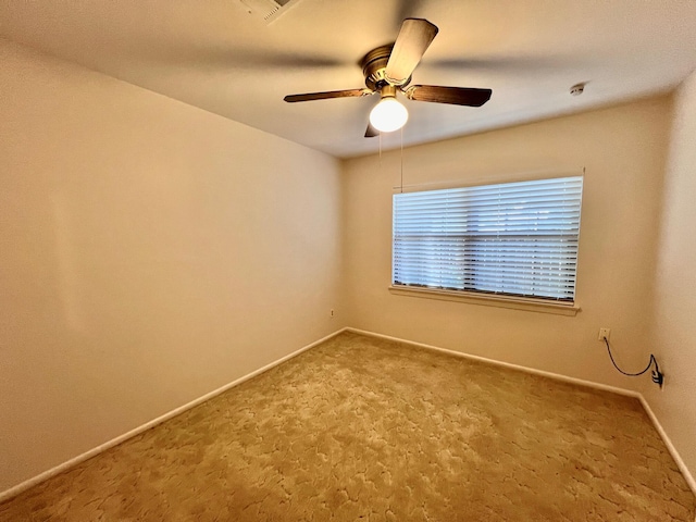 carpeted spare room with ceiling fan