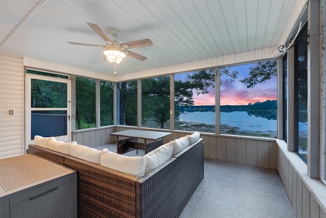 sunroom with a water view and ceiling fan