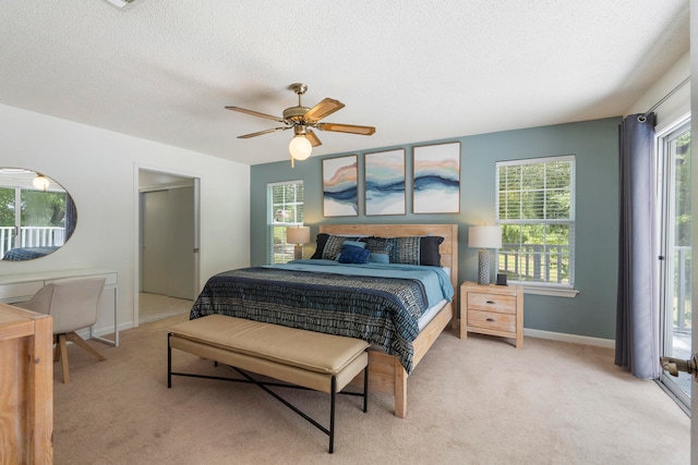 carpeted bedroom featuring multiple windows, a textured ceiling, and ceiling fan