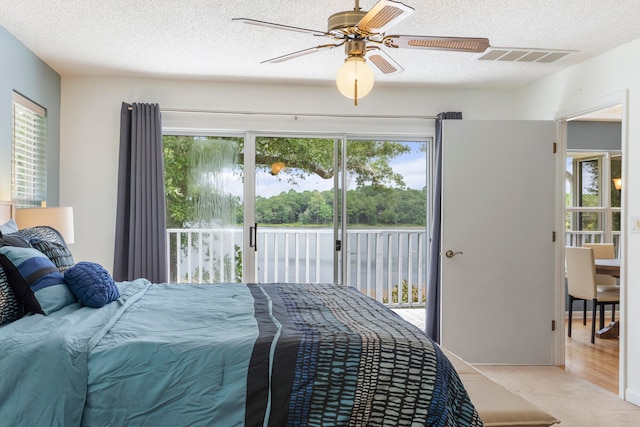 bedroom featuring a textured ceiling, wood-type flooring, ceiling fan, and access to exterior