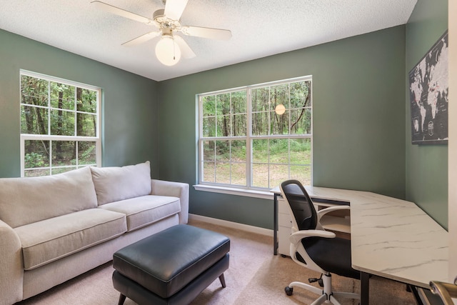 carpeted office featuring a textured ceiling and ceiling fan