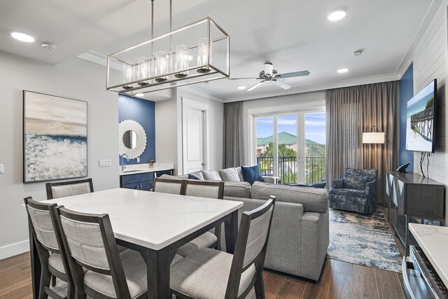 dining space with sink, ceiling fan, dark hardwood / wood-style flooring, and crown molding