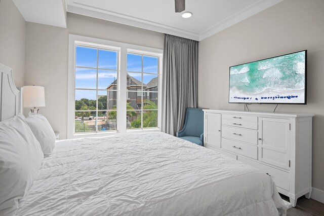 bedroom featuring ceiling fan, multiple windows, and ornamental molding