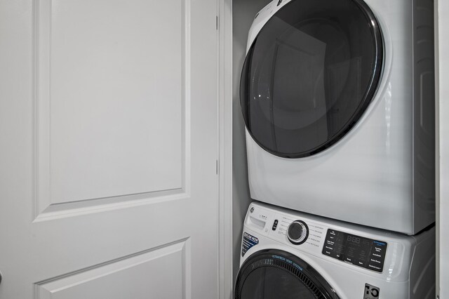 clothes washing area with stacked washer and dryer