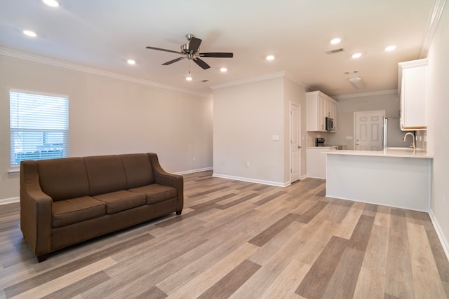 living room with sink, ornamental molding, ceiling fan, and light hardwood / wood-style floors