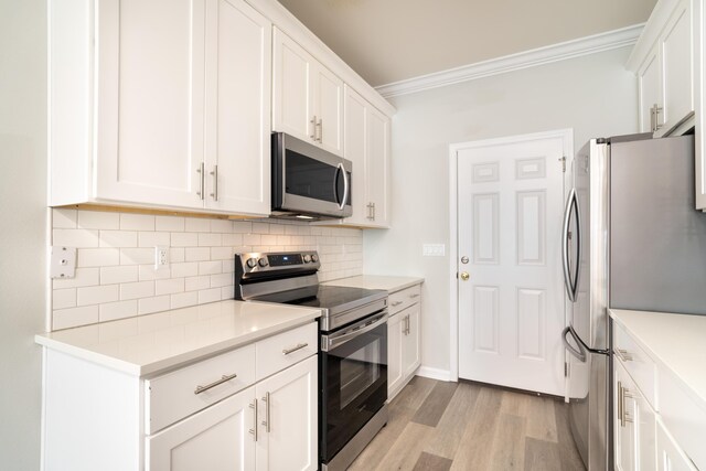 kitchen with white cabinetry, crown molding, light wood-type flooring, appliances with stainless steel finishes, and backsplash