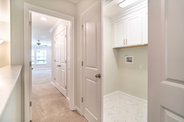 interior space featuring light carpet, cabinets, ceiling fan, and washer hookup