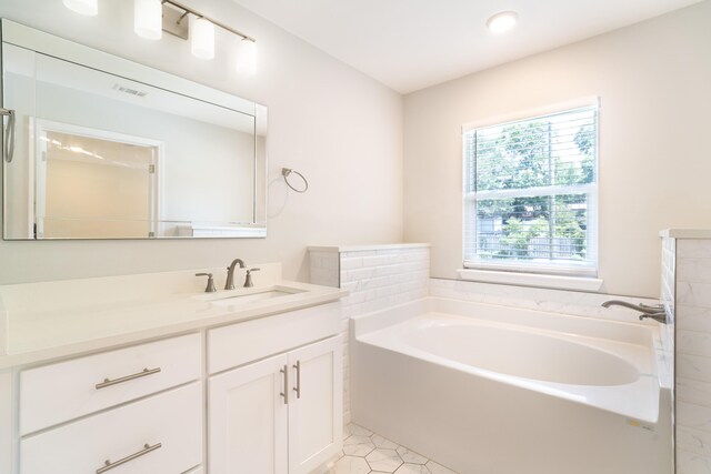 bathroom featuring vanity, a tub to relax in, and tile patterned flooring