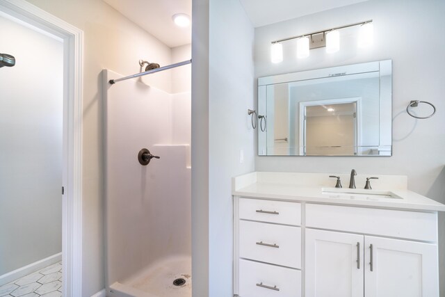 bathroom with a shower, vanity, and tile patterned flooring