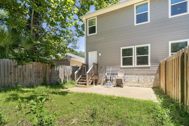 back of house with a lawn and a patio area