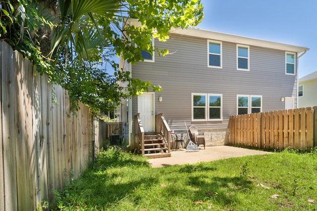 back of house with a patio area and a yard