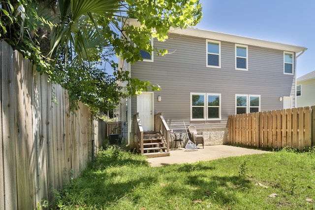 back of property with a lawn and a patio area