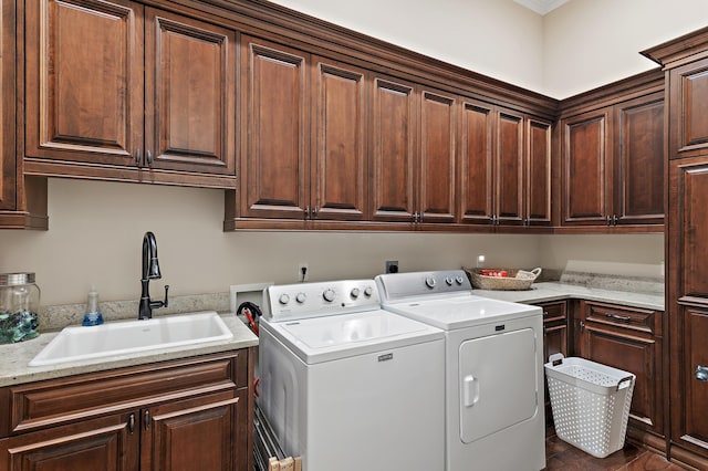 laundry room with washing machine and dryer, cabinet space, and a sink