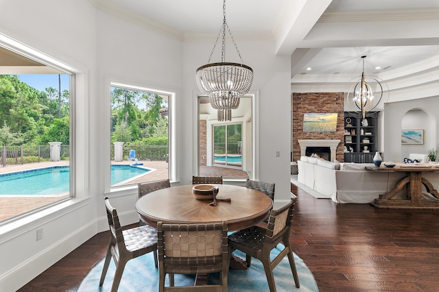 dining area featuring ornamental molding, wood-type flooring, baseboards, and an inviting chandelier