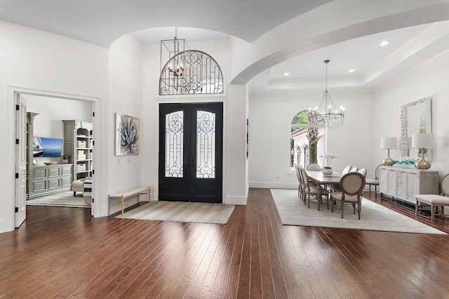 foyer featuring a chandelier, french doors, a tray ceiling, and wood-type flooring