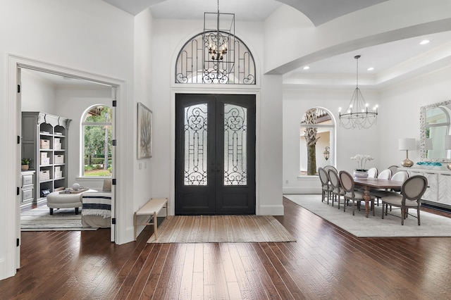 entryway featuring a chandelier, french doors, dark wood-type flooring, and baseboards