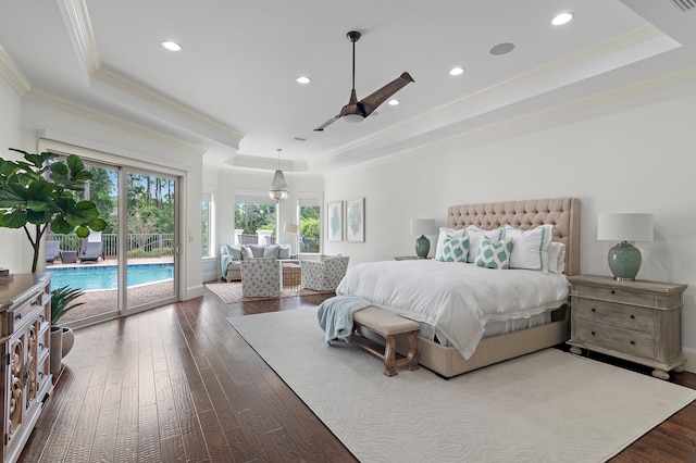 bedroom with ornamental molding, a tray ceiling, dark wood-style flooring, and access to exterior